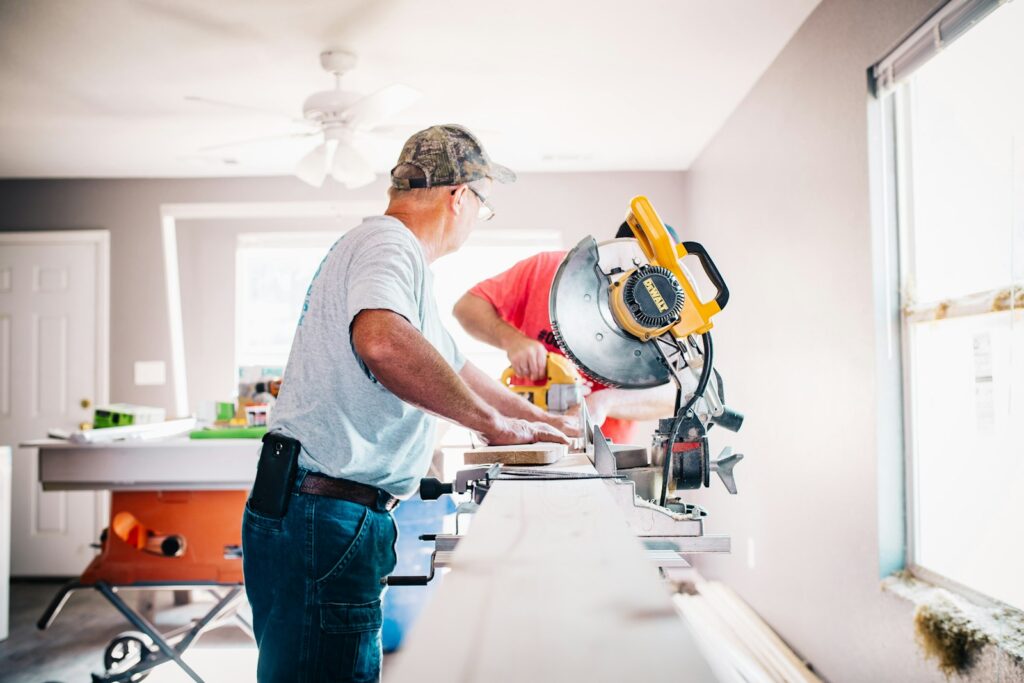 Crew member cutting trim with a miter saw